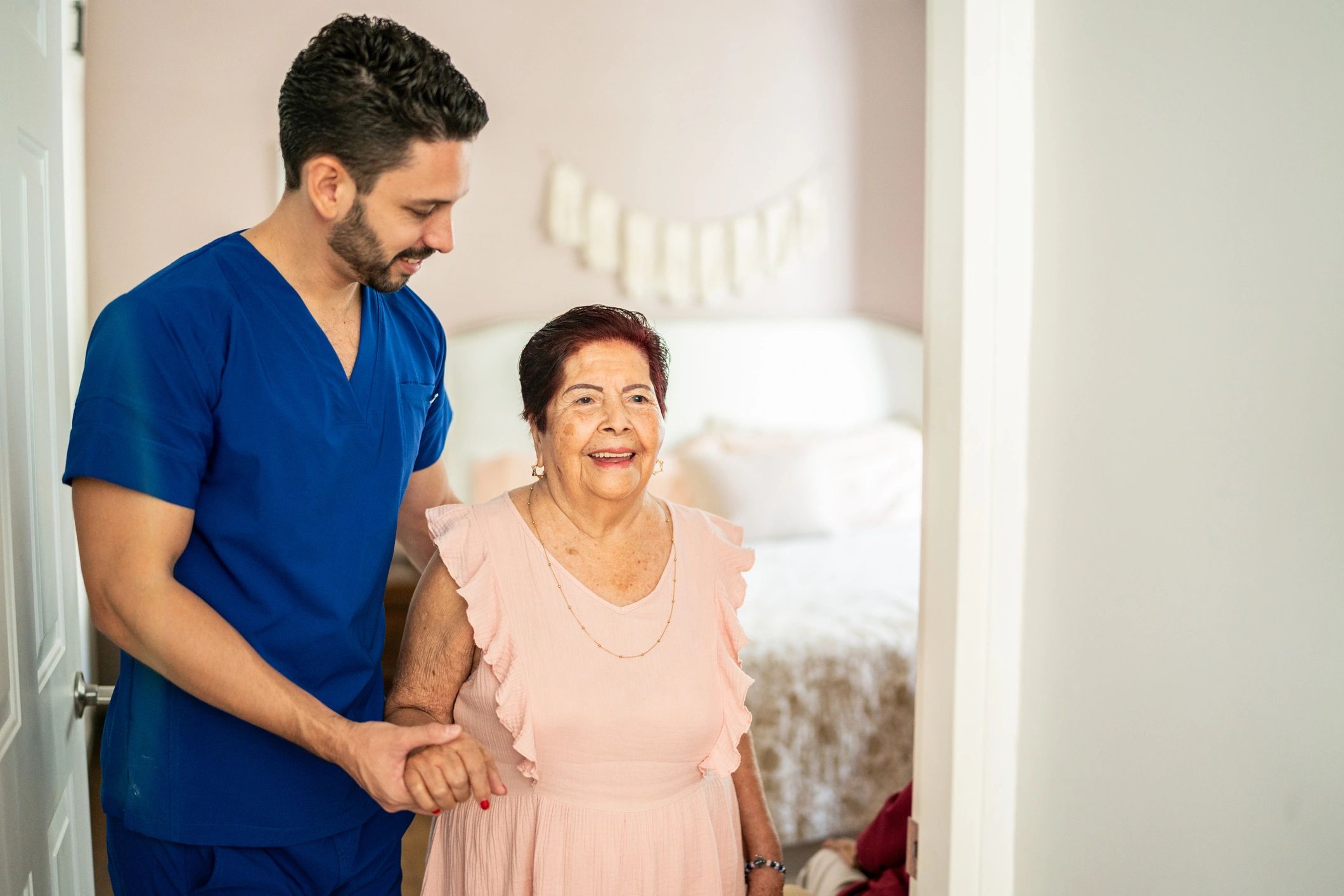 Caregiver assisting a senior woman walking at home