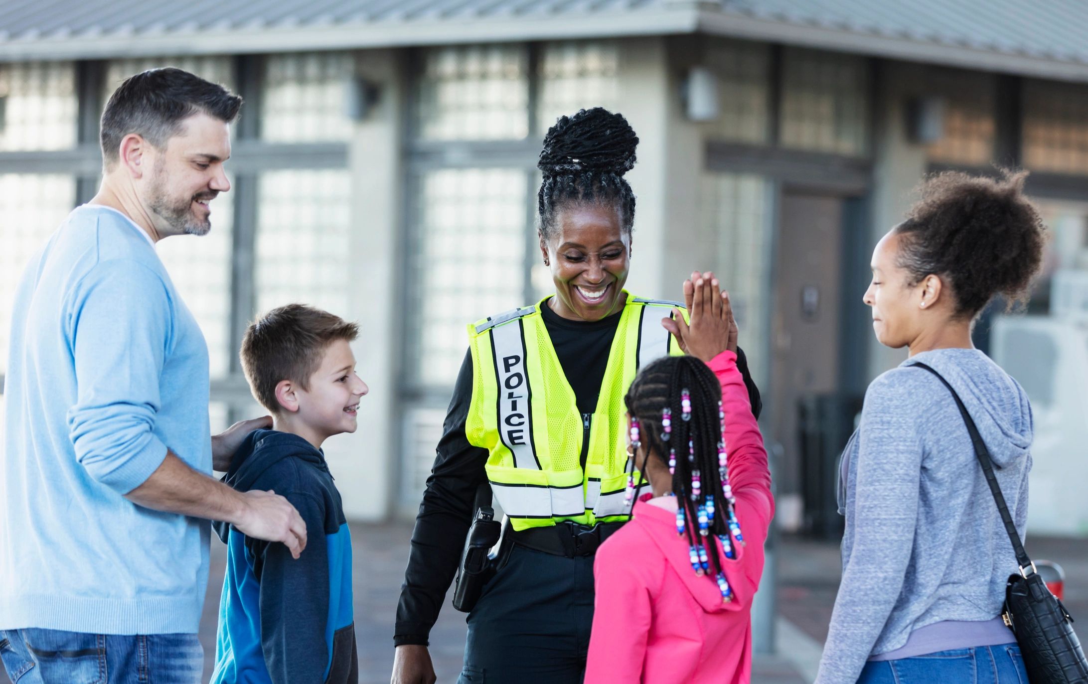 Police officer speaking with families outdoors